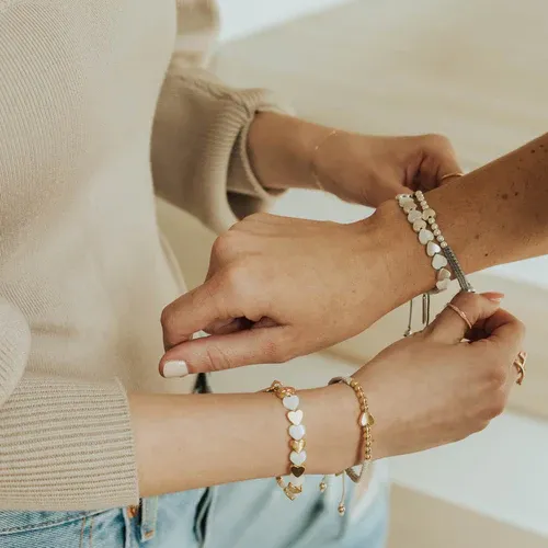a still of two people tying friendship bracelets on each others hands