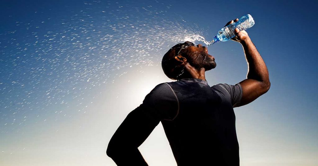 an athlete drinking water from a bottle