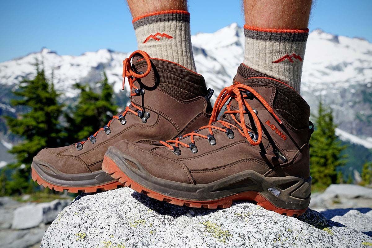 a picture of hiking shoes on a rock with snowy mountains in the background