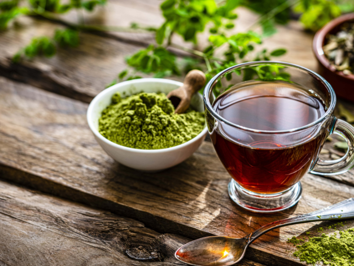 an image of green tea in a cup with green tea powder on the side 